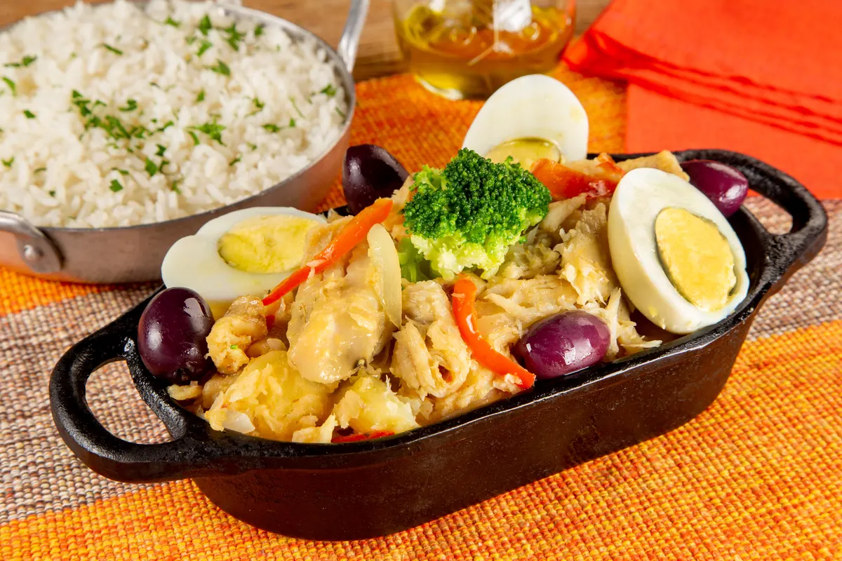 Bacalhau à moda na travessa com ovos, legumes e arroz ao lado