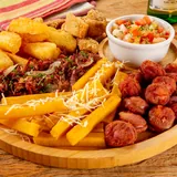 Pratada mineira com linguiça, mandioca, polenta frita e vinagrete sobre tábua